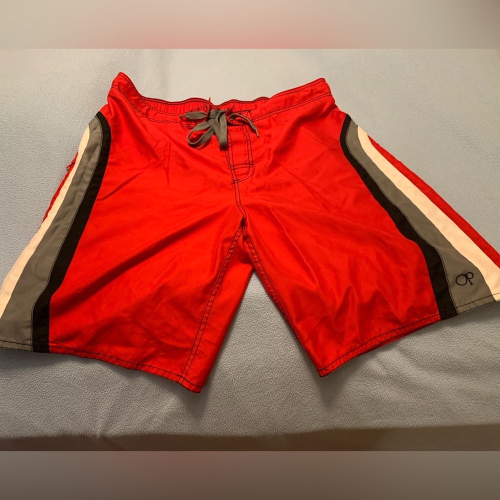 Two pair of men’s swim trunks. Both are size 36-38. Both have pockets. Both Red